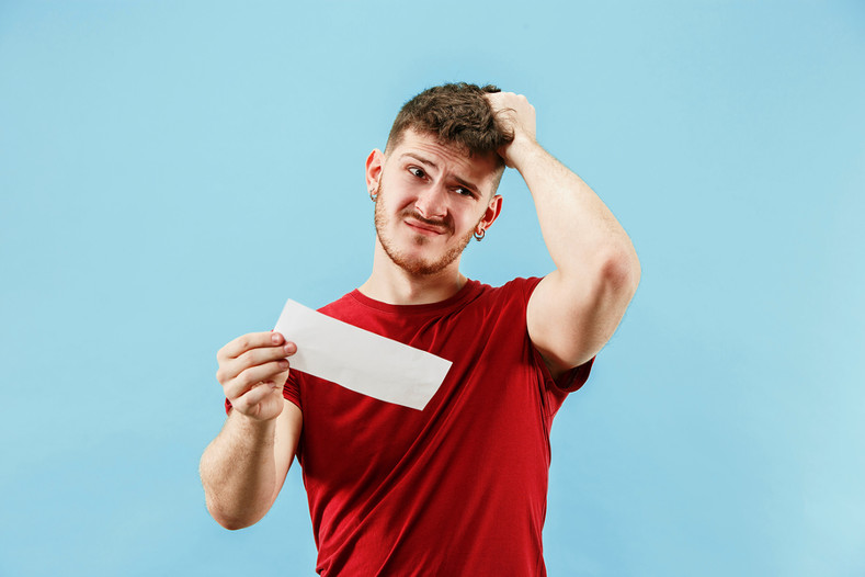Confused man holding bet slip