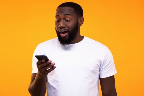 Surprised man checking phone