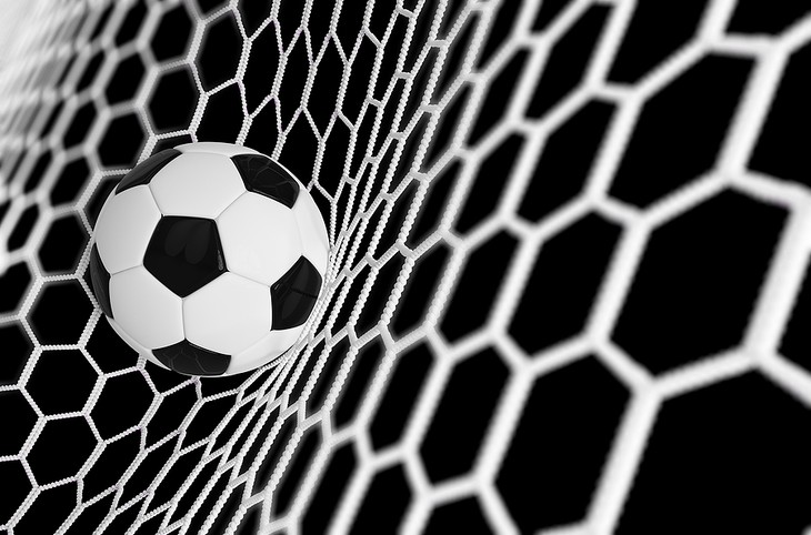 Football Striking Goal Net Against Black Background